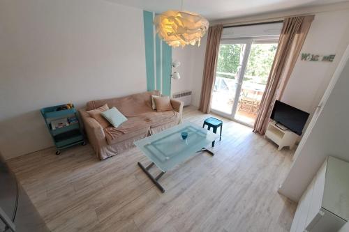 un salon avec un canapé et une table basse dans l'établissement Charming T2 - close to the 