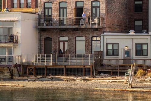 a building with people on a balcony next to the water at The Belmont Hotel in Port Townsend