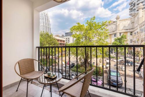 a balcony with chairs and a table and a view of a city at XiShuangBanNa Fanshe resort in Jinghong