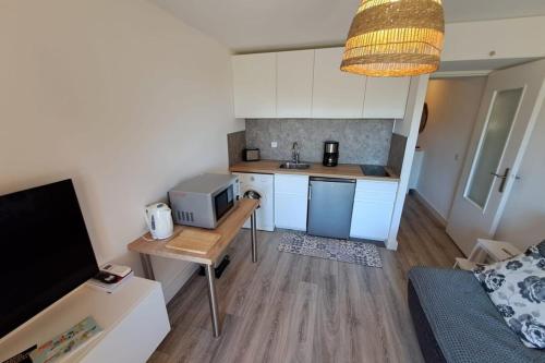 une petite cuisine avec une table et un micro-ondes dans l'établissement Apartment 300 m from Saint-Clair beach, au Lavandou