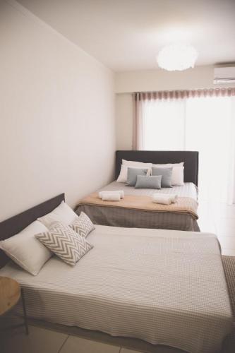 a bedroom with two beds and a window at Ιasonas Apartment in Nafplio