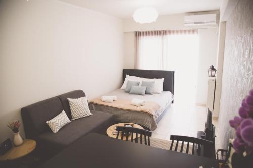 a small living room with a couch and a bed at Ιasonas Apartment in Nafplio