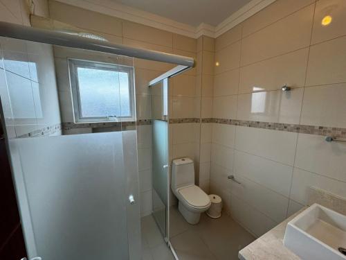 a bathroom with a toilet and a shower and a sink at Apto 2 in Florianópolis