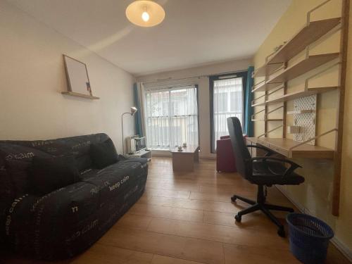 - un salon avec un canapé noir et une chaise dans l'établissement STUDIO hyper-centre de La Rochelle - LR180-014, à La Rochelle