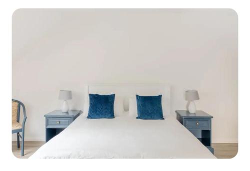 a bedroom with a white bed with blue pillows at The Boat Shed, Westport in Westport