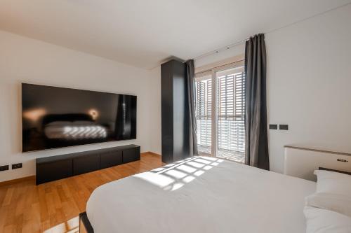 ミラノにあるGiax Tower Luxury Oasisのベッドルーム(ベッド1台、大画面テレビ付)