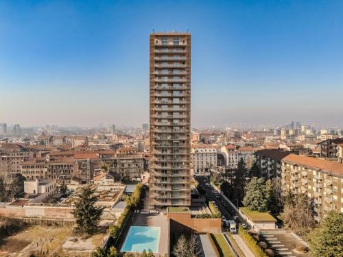 a tall building with a pool in front of a city at Giax Tower-Pool,Spa&Gym-Niguarda Hospital-10min to Duomo in Milan