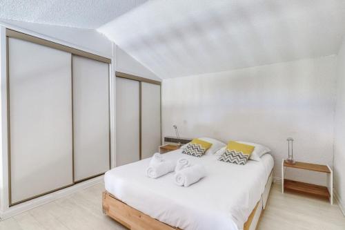 une chambre avec un lit blanc avec deux oreillers dans l'établissement Direct access to the beach residence with swimming pool, au Lavandou