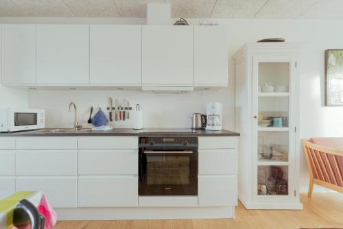 a kitchen with white cabinets and a black oven at 1 BR Apartment - Tórshavn - Parking in Tórshavn