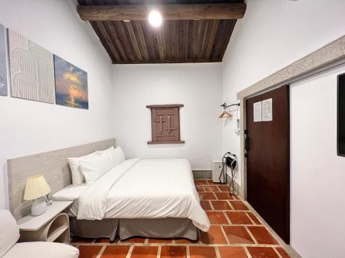 a bedroom with a bed in a room with white walls at 金門 湖光悠宅古厝民宿 Relax Lake B&B in Lin-ts'o