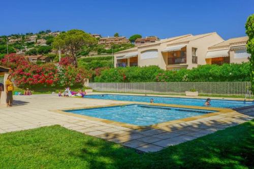a swimming pool in front of a house at Family apartment - beach access swimming pool in Le Lavandou