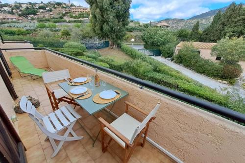 a patio with a table and chairs on a balcony at Family apartment - beach access swimming pool in Le Lavandou