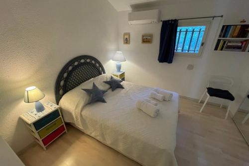 une chambre avec un grand lit blanc avec deux oreillers dans l'établissement Duplex in Pramousquier - sea view, au Lavandou