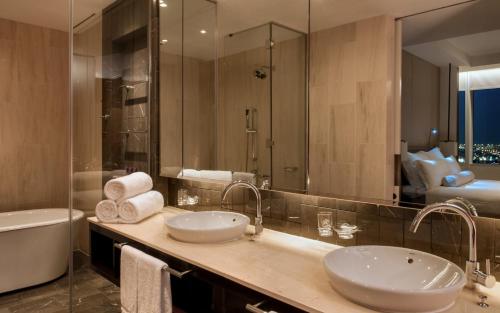 a bathroom with two sinks and a tub and a mirror at InterContinental Dubai Festival City by IHG in Dubai