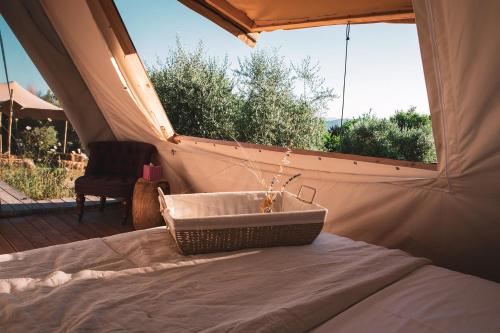 Eine Badewanne, die auf einem Bett in einem Zelt steht. in der Unterkunft Palare in Montone