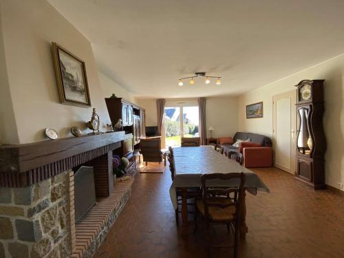 un salon avec une table et une cheminée dans l'établissement REF 007 Maison vue mer trois chambres sept personnes avec jardin KERMOR ARZON, à Arzon