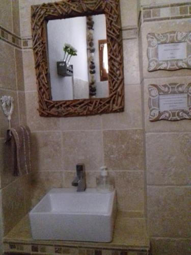 une salle de bain avec un lavabo blanc et un miroir dans l'établissement Le Mas Joyeux - Le Lys - Gite En Cévennes, à Saint-Florent-sur-Auzonnet