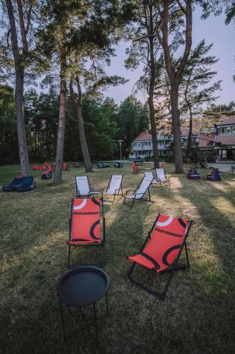 a group of chairs sitting in the grass at Skalva Nida in Nida