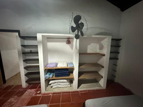 a small room with a white closet with a fan at Praia do Veloso - Ilha Bela in Ilhabela
