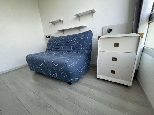 - une chambre avec un lit bleu et une commode dans l'établissement Appt Studio LA ROCHELLE - LR810-315, à La Rochelle