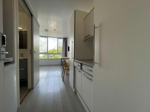 une cuisine avec des placards blancs et une grande fenêtre dans l'établissement Appt Studio LA ROCHELLE - LR810-315, à La Rochelle