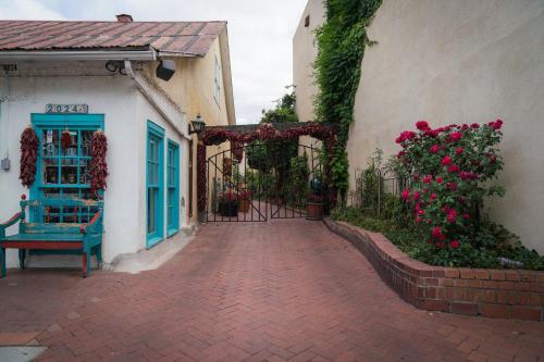 a brick walkway next to a building with a gate and flowers at Holiday Inn Express & Suites Albuquerque Historic Old Town by IHG in Albuquerque