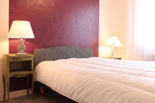 - une chambre avec un lit et une lampe sur une table de chevet dans l'établissement Appt 2 pièces LA ROCHELLE - LR180-055, à La Rochelle