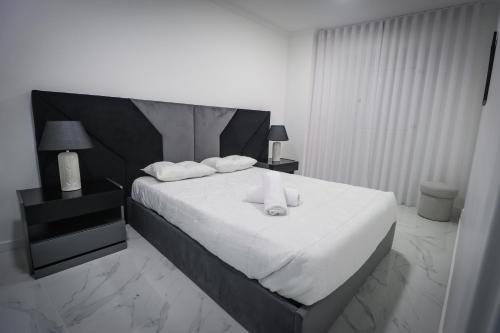 a bedroom with a bed with two white towels on it at Apartamento Amanhecer in Rabo de Peixe