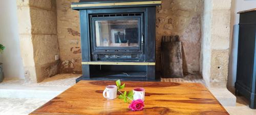 a wooden table with two candles on top of a fireplace at La petite maison du Ramail in Badefols-dʼAns