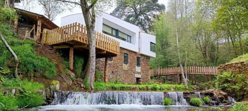 a house on a hill with a waterfall at Quinta da Azenha in Nespereira
