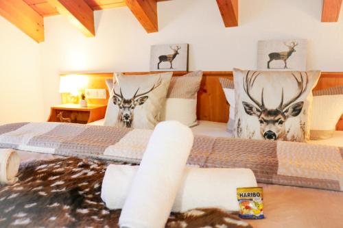 een slaapkamer met een bed met hertenkoppen op de kussens bij House of Happiness by apartmentglück in Schluchsee