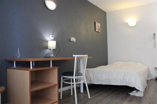 une chambre avec un lit, un bureau et une chaise dans l'établissement Appt Studio LA ROCHELLE - LR030-B22, à La Rochelle