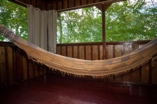 a hammock in a room with a window at Vista do Lago Jungle Lodge in Cajual