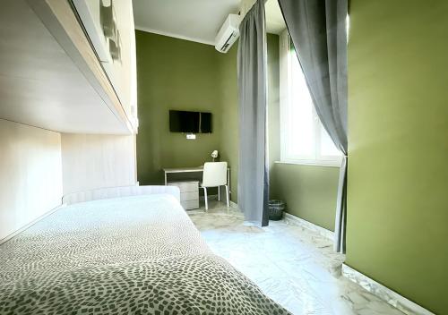 a bedroom with a bed and a desk and a window at Mi casa tu casa - Guest House in Catania