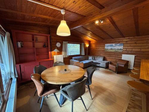 a living room with a wooden table and chairs at Vakantieoord De Bronzen Emmer in Meppen
