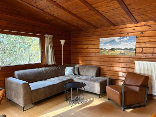 a living room with a couch and a table at Vakantieoord De Bronzen Emmer in Meppen