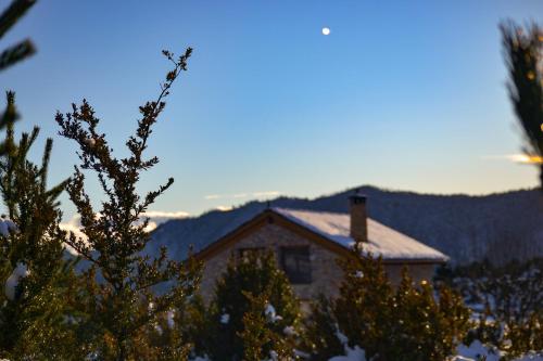 a house with a snow covered roof and a tree at As Fuebas de Patricio in Vío