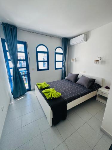a bedroom with a bed and two windows at Bungalow Gilly in Maspalomas