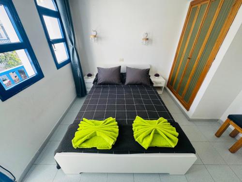 a bedroom with a bed with yellow pillows on it at Bungalow Gilly in Maspalomas