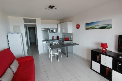 Il comprend une cuisine et un salon avec un canapé rouge. dans l'établissement T2 in Saint-Clair - Exceptional view! Rated 3, au Lavandou