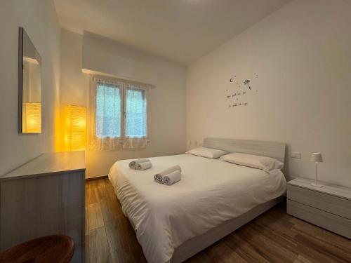 a bedroom with a large bed with white sheets at Petra House in Porlezza