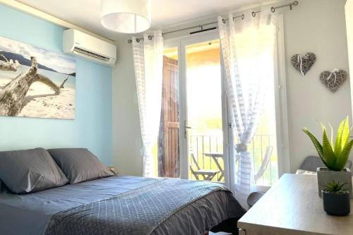 une chambre avec un lit et un balcon dans l'établissement Magnificent T3 - Saint-Clair - 500m from the beach, au Lavandou
