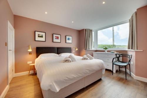 Un dormitorio con una cama y un escritorio y una ventana. en Art House Seahouses, en Seahouses