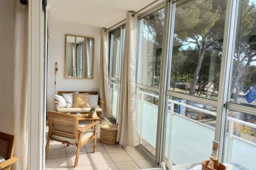 a living room with large windows and a couch at T2 vue à 100m de la plage avec parking privé in Bormes-les-Mimosas