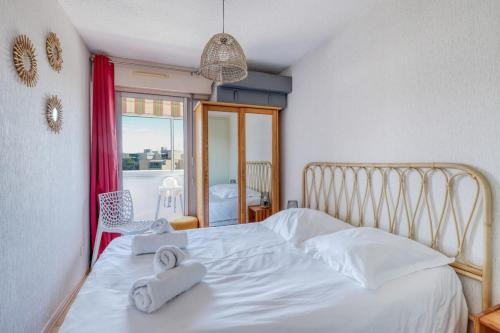 une chambre avec un lit blanc avec deux serviettes dessus dans l'établissement T2 600 m from the beach! Air-conditioned, au Lavandou