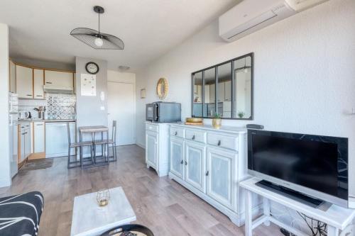 un salon avec une grande télévision à écran plat dans l'établissement T2 600 m from the beach! Air-conditioned, au Lavandou