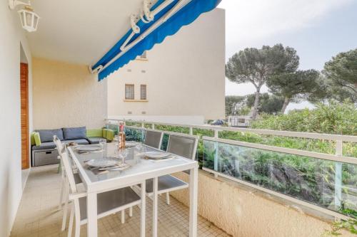 une salle à manger avec une table et des chaises et un balcon dans l'établissement Recent T3 in residence with swimming pool in La Favière, à Bormes-les-Mimosas