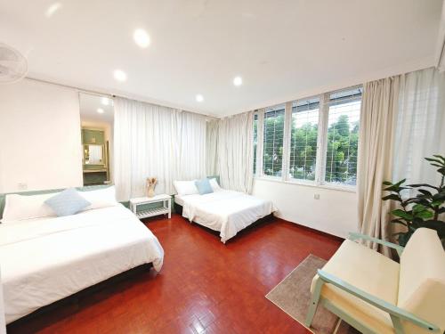 a bedroom with two beds and a couch and windows at HT Homestay BigSemi-D BBQwedding in town in Jelutong