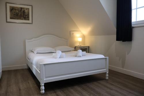 a white bed with two white towels on it at Domaine La Grande Bruyère in Touffréville