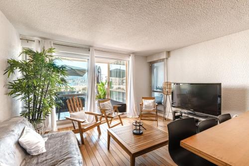 a living room with a couch and a flat screen tv at Superb apartment on the port of Favière in Bormes-les-Mimosas